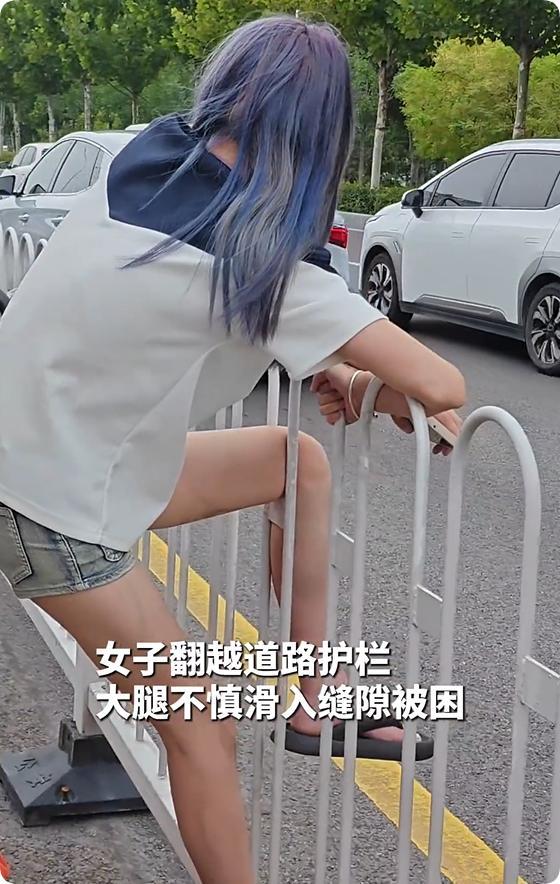 精神小妹横穿马路被卡护栏上路人忍不住想笑：帮不上忙等消防(图2)