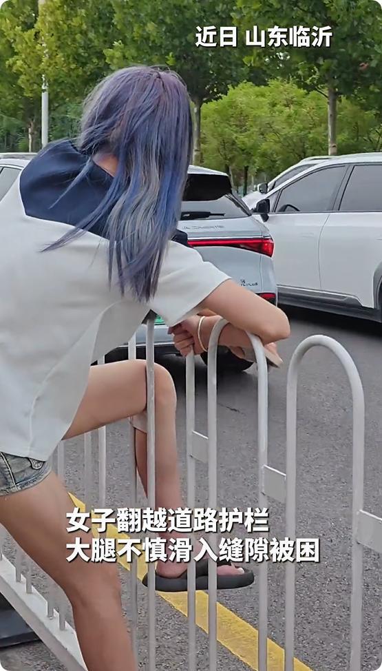 精神小妹横穿马路被卡护栏上路人忍不住想笑：帮不上忙等消防